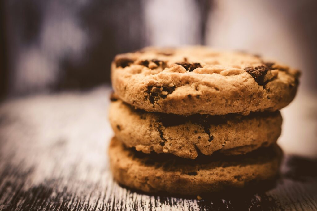 Política de cookies A macro shot of freshly baked stacked chocolate chip cookies creates a cozy dessert vibe.